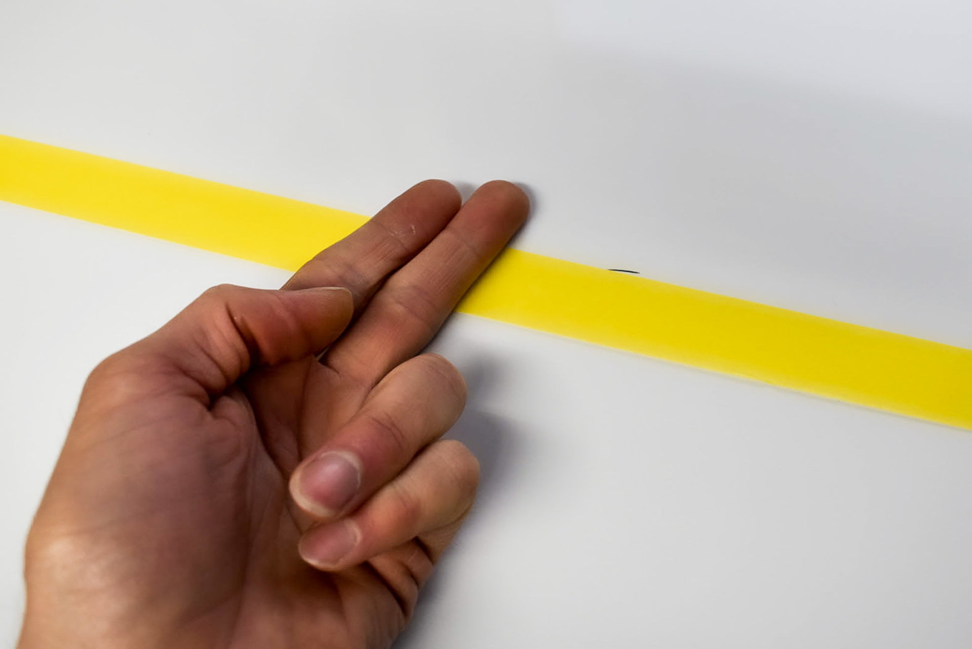 Firming masking tape into position for sign painting