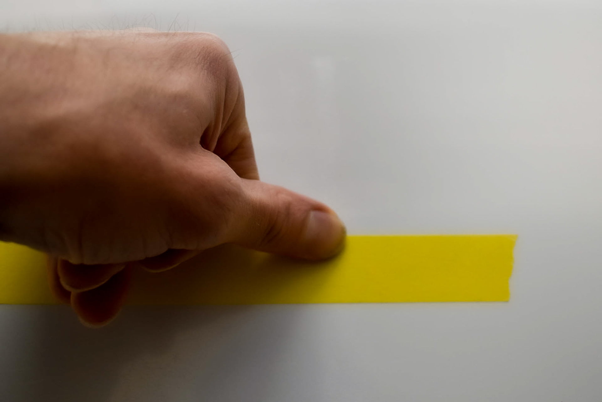 Pressing masking tape onto sign surface