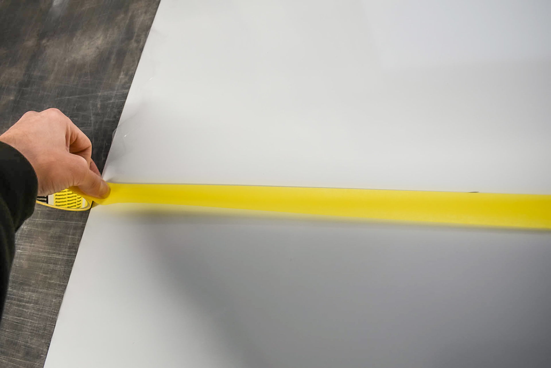 Pulling masking tape tight for sign painting